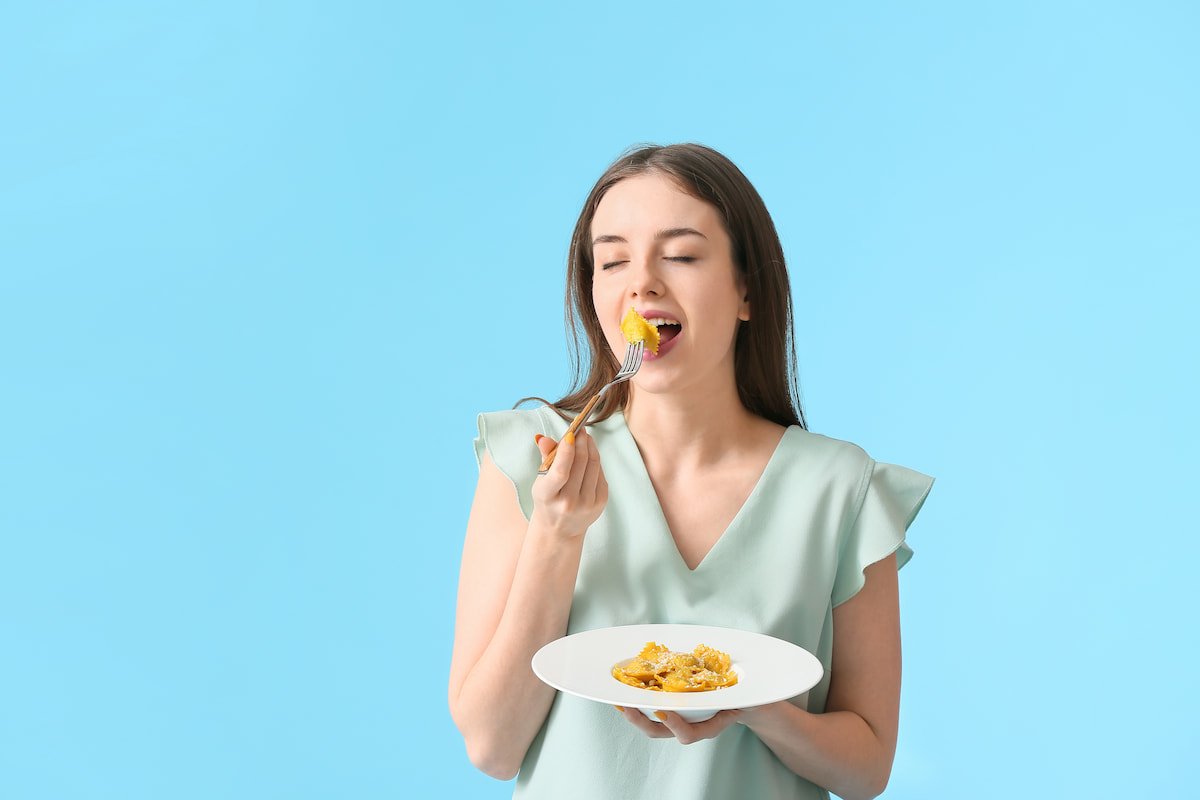 an young woman is eating tasty ravioli