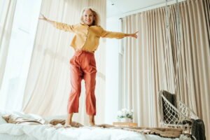 Energy and joyfully jumping on the bed women